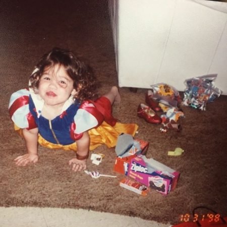 Madison McLaughlin at two years old wearing a Snow White costume and lying in the floor.