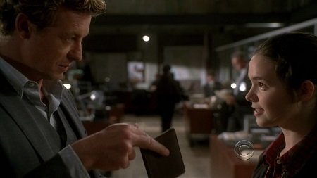 The scene where Patrick Jane (Simon Baker) teaches Anne (Madison McLaughlin) how to pickpocket. Simon holding a wallet in front of Madison, pictured sideways.