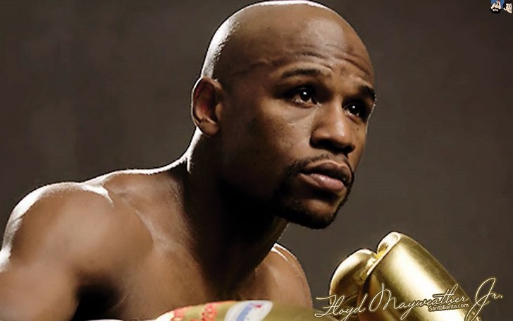 Floyd Mayweather Jr.'s signed photo wearing golden boxing gloves. His Net Worth is estimated to be $565 million.