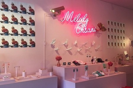 Melody Ehsani written in neon lights inside her store.