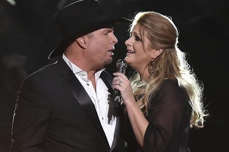 Garth Brooks and Trisha Yearwood facing each other and singing together.