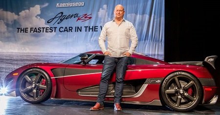 Christian von Koenigsegg standing in front of the fastest car in the world, Koenigsegg Agera RS in red color, at the Canadian International Auto Show in Toronto.