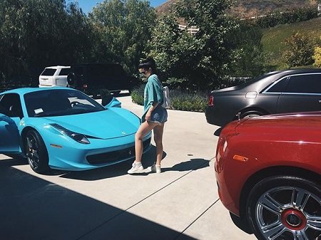 Kylie Jenner in front of the blue 458 Spyder.