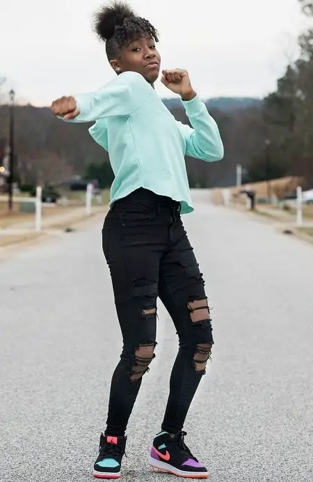 Jalaiah Harmon on the streets of her hometown posing a move from her Renegade Dance.