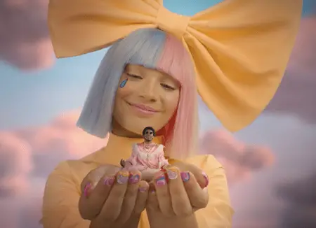 Maddie Ziegler in the 'No New Friends' video holding miniature sized (by photoshop) Labrinth on her hands.