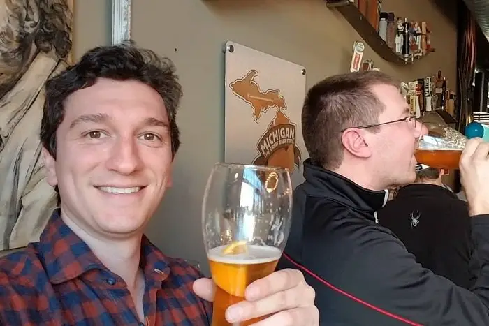 Alex Lagina holding a glass of beer in celebration.