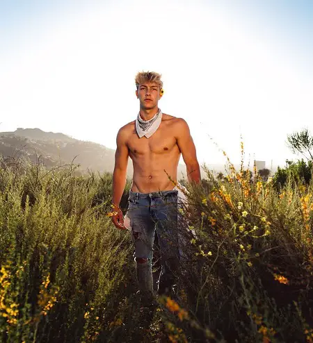 Tayler Holder going shirtless in a field.