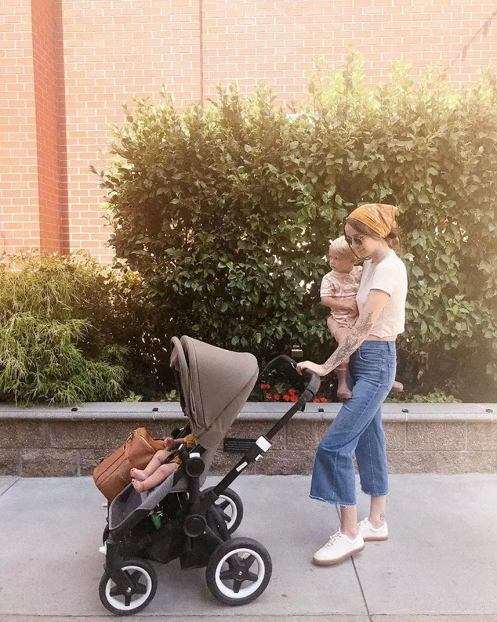 Acacia Kersey with one of her children in her hand and her other child in a stroller.