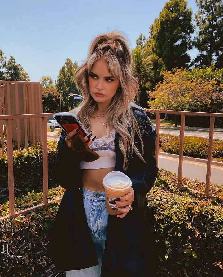 Ash Levi with coffee and phone on her hands.