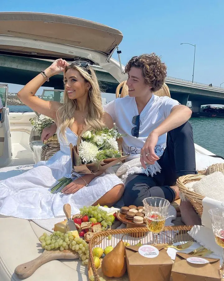 Lexi Hensler and Paris Rosenbaum enjoying a picnic on a yacht.