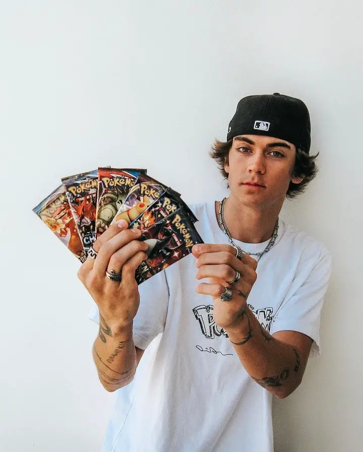 Zack Lugo Holding a number of Pokemon cards in his right hand.