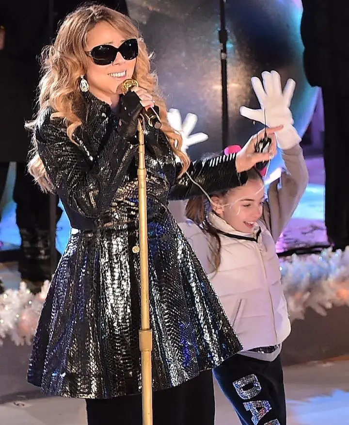 GiaNina Paolantonio (right) right beside Mariah Carey (left) singing during her performance at the NBC Rockefeller Christmas Tree Lighting Event in 2014.