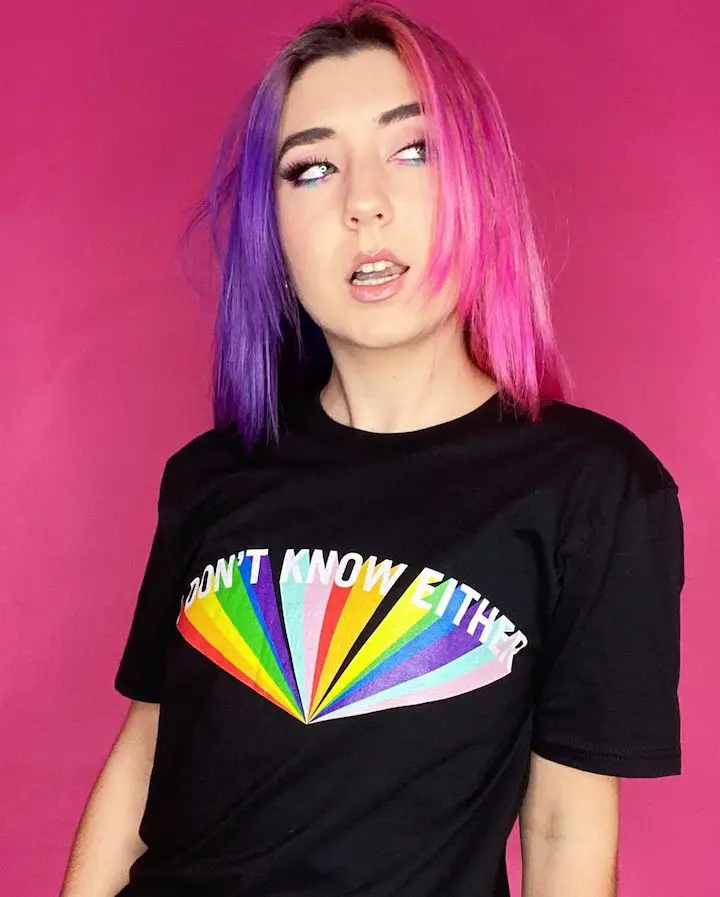 Hannah Forcier wearing an LGBTQ+ T-shirt that reads 'I don't know either' making a face looking to her left.