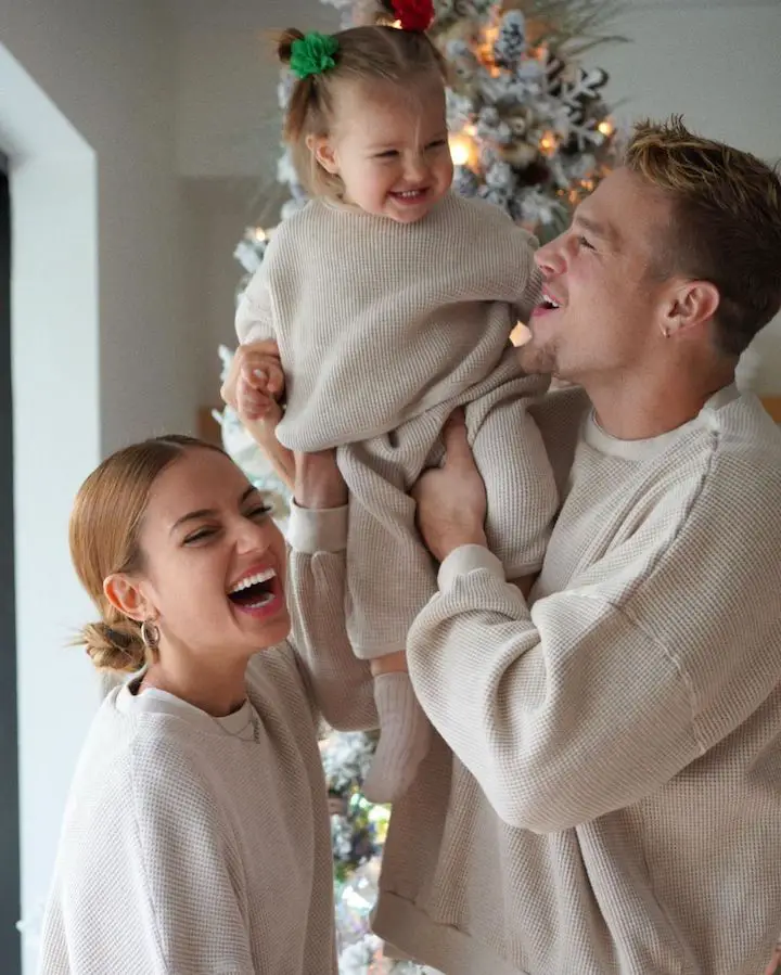 Inanna Sarkis (left) with her boyfriend Matthew Noszka (right) carrying their daughter Nova (center) during Christmas.