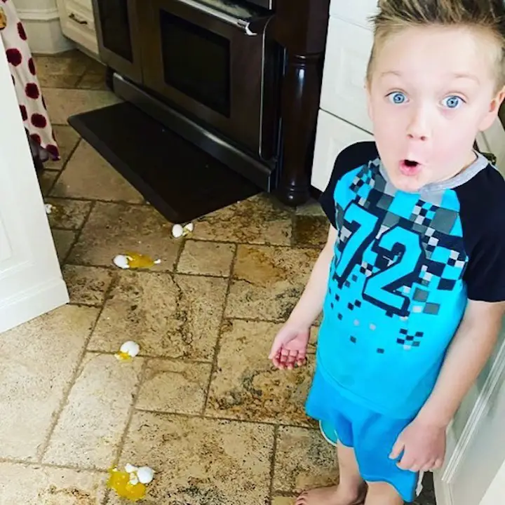 Kayson Myler gives a shocked look at the camera with shells of broken eggs on the floor.