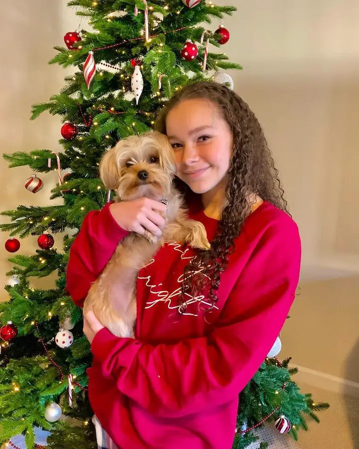 Olivia Haschak in red sweater holding Sierra Haschak's dog.