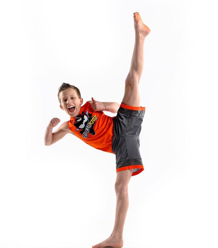 Paxton Myler stretching his legs out in the air as part of a karate move.