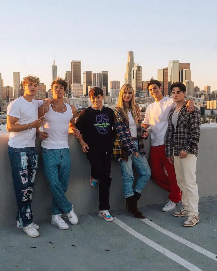 The Elevator Boys members and Heidi Klum (third from right) posing on a balcony wall.
