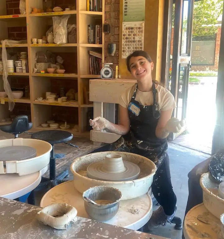 Sima Hesri getting her hands muddy while in a pottery session.