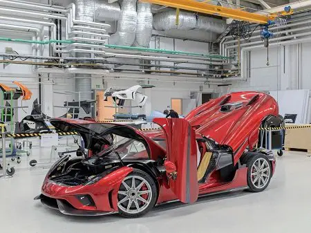 A red Koenigsegg Regera at the factory in Angelholm, all separable parts lifted..