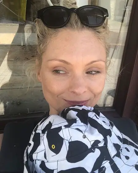 MyAnna Buring with her son covered by a panda hat resting on her chest.