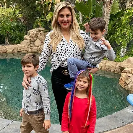 Gina Kirschenheiter with her three kids with the youngest in her one arm.