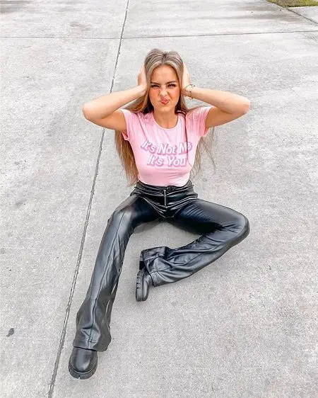 Addison Rae wearing a Fashion Nova sponsored T-shirt while sitting on the floor.