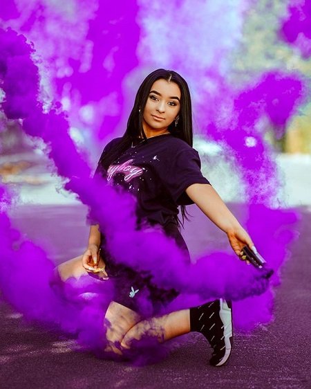 Danielle Cohn using a purple flare for a pose photo.