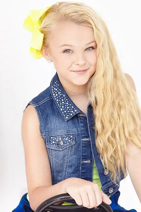 JoJo Siwa without her ponytail but with a yellow bow.