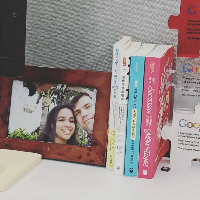 A photo of Sarah Cooper and her husband on a desk with her three released books.