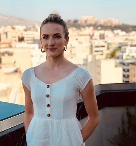 Julie Nolke in a white dress in an European city.