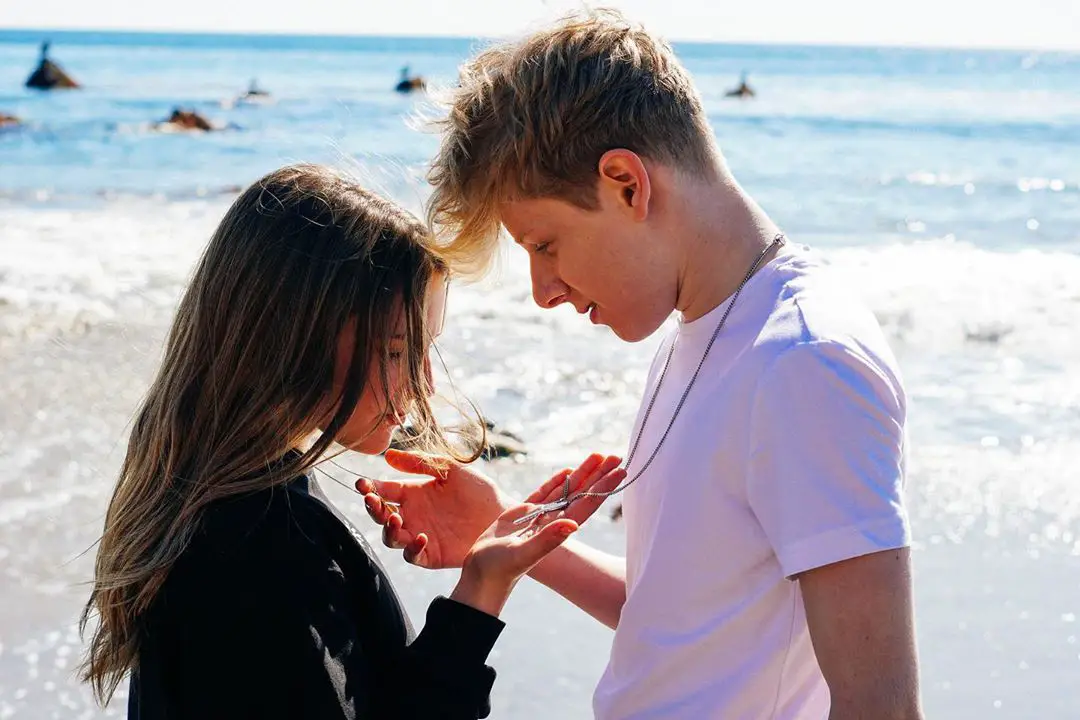 Piper Rockelle looking at a locket on Lev Cameron's neck.