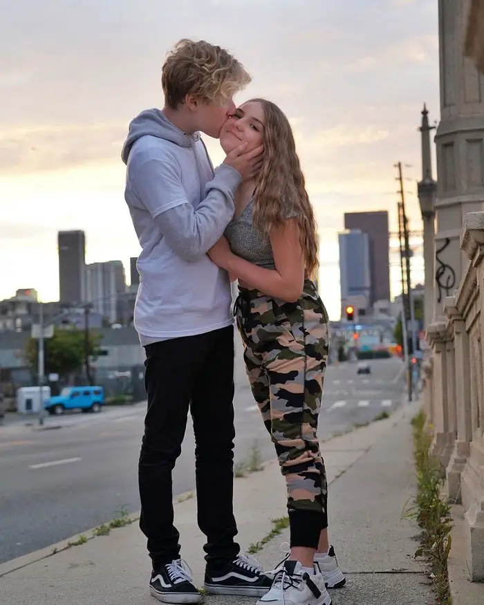 Lev Cameron kissing girlfriend Piper Rockelle in her cheek as she smiles.