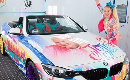 JoJo Siwa in front of her car for her house article.