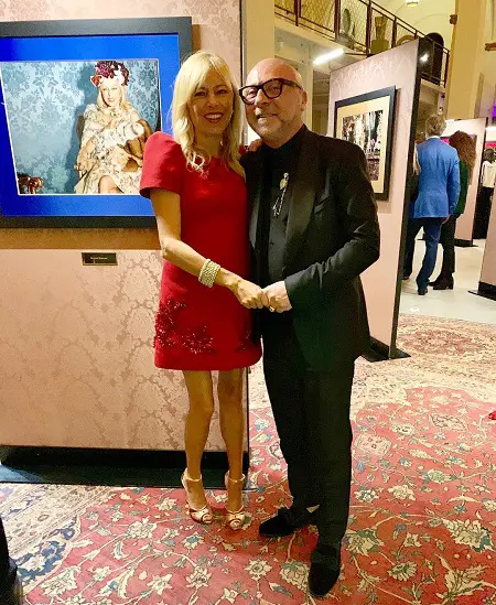 Sutton Stracke hand-in-hand with Dolce & Gabbana's Domenico Dolce in an art gallery.