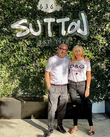 Domenico Dolce with his arm around Sutton Stracke in front of her boutique establishment.