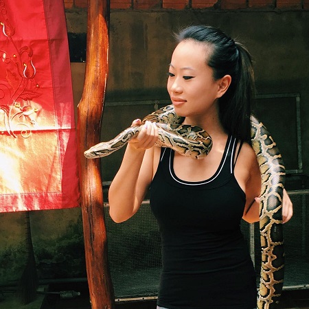 Kelly Mi Li with a snake around her shoulders.