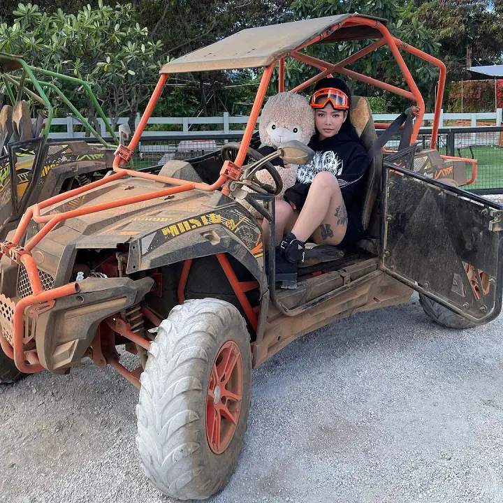 Bella Poarch in her Dune Buggy with one of her goat plushies.