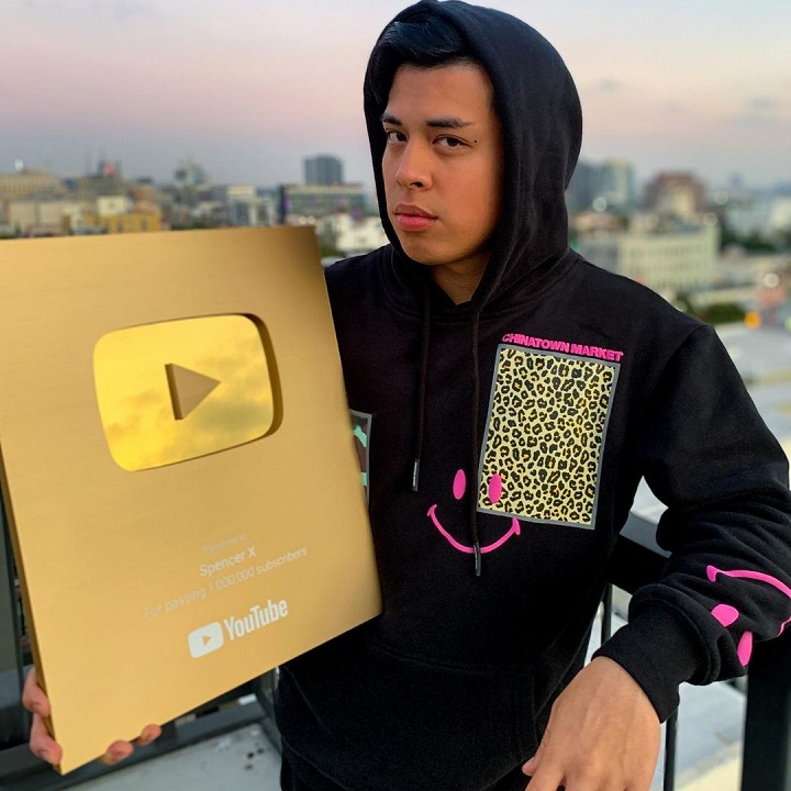 Spencer X holding his million-subscriber YouTube plaque in February 2020.