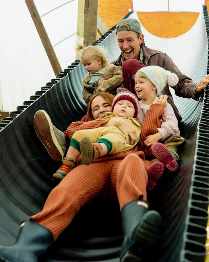 Acacia Kersey with her husband Jarius Kersey and three kids on a playground slide.