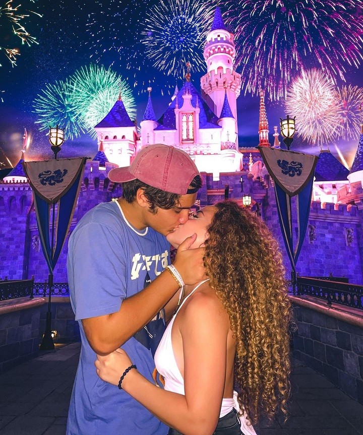 Sofie Dossi and her boyfriend Dom Brack kissing in front of the Disneyland Palace during an evening date.