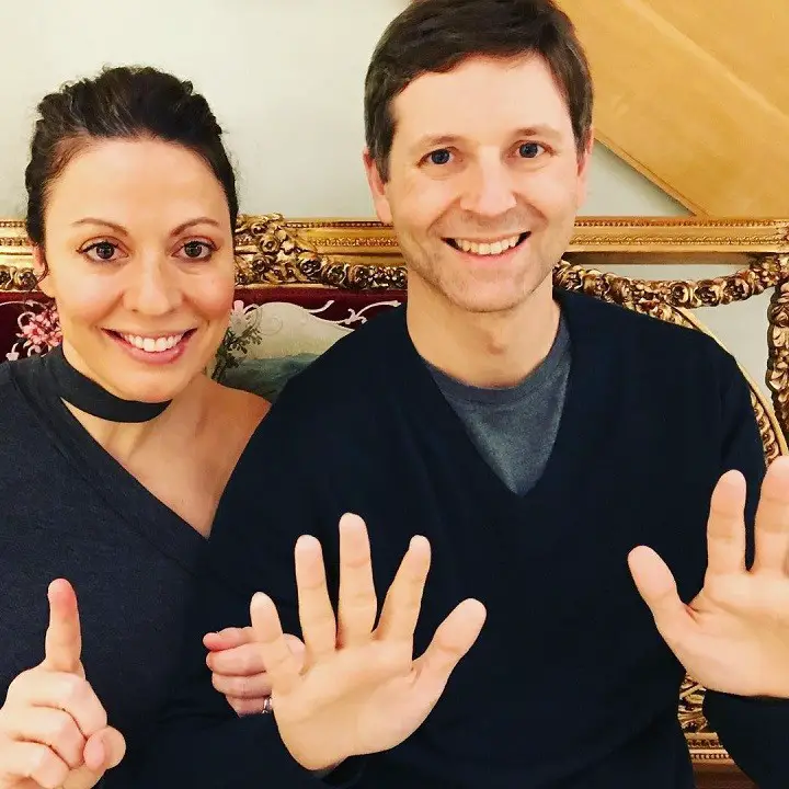 Kay Cannon (left) and husband Eben Russell (right) celebrating their 11-year first date anniversary holding 11 finger in total together.