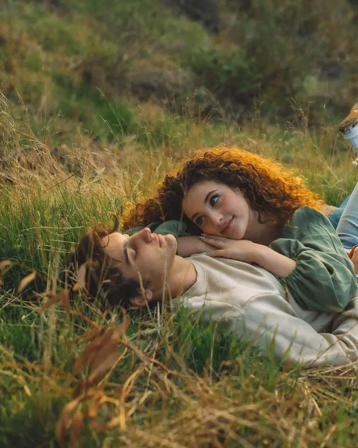 Sofie Dossi watching romantically on Dom Brack while laying on the grass.