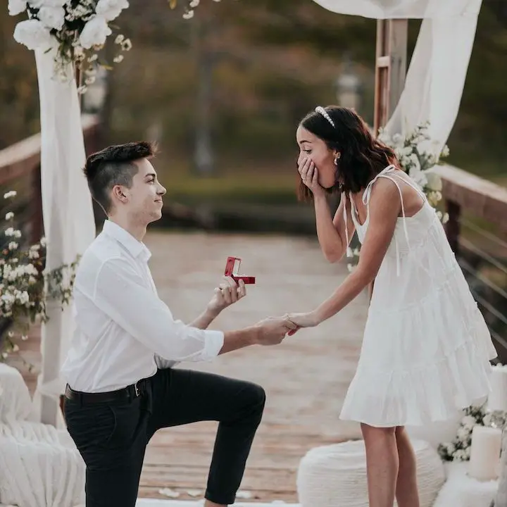 Bailey McKnight-Howard (right) gasping as she is proposed by her boyfriend-turned husband Asa Howard (left) who is on one knee.