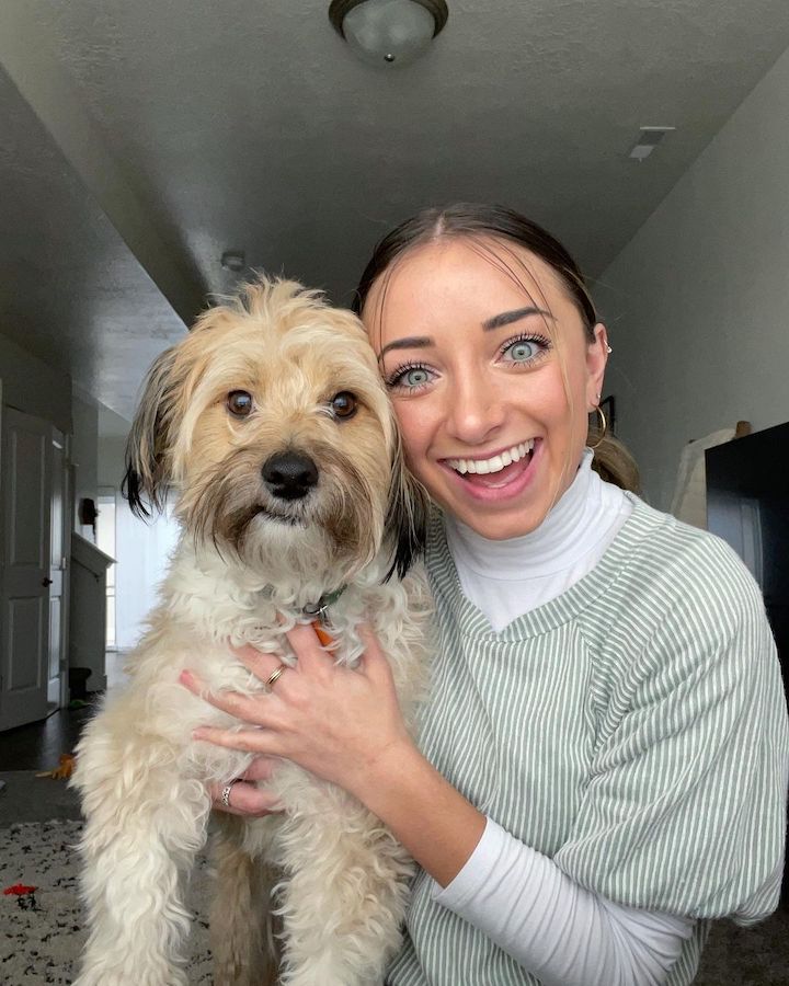 Brooklyn McKnight posing for a photo with her pet dog.