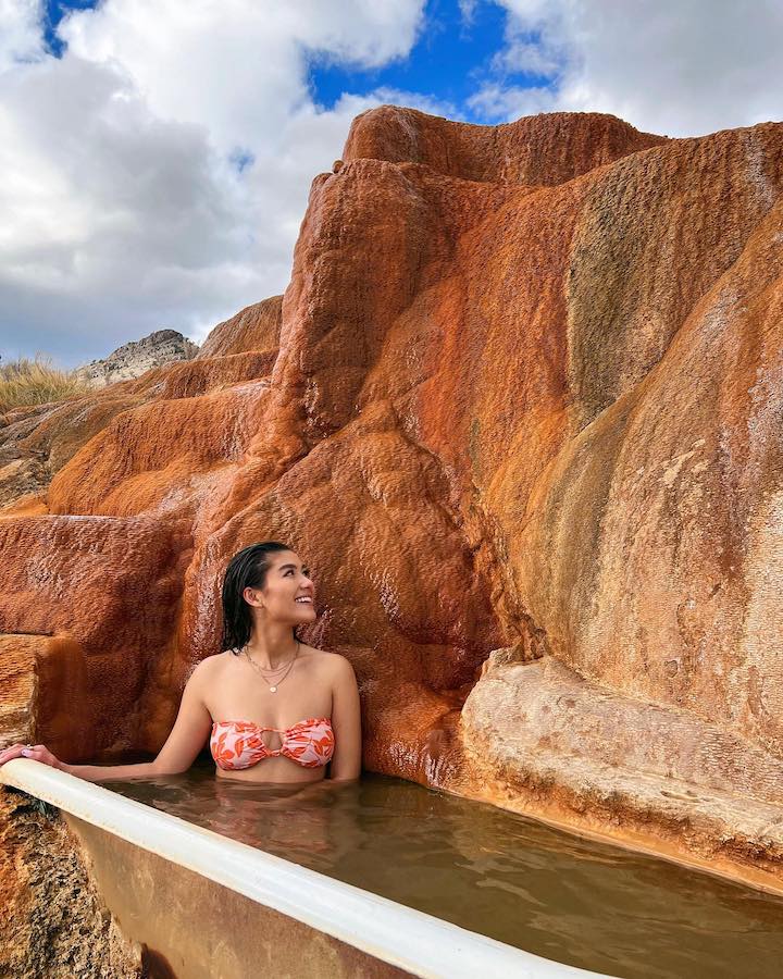Kirsten Titus in a hot tub designed with a Grand Canyon background looking away from the camera.