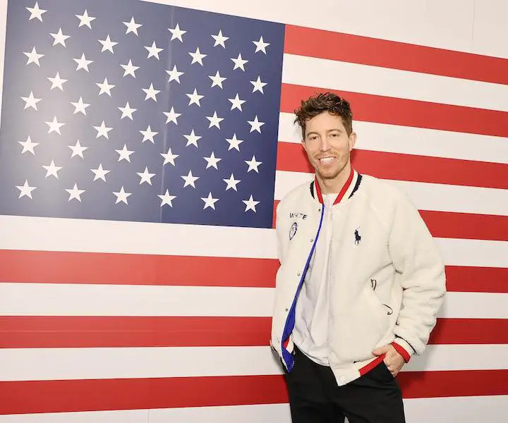 Shaun White standing in front of an American flag for a photo pose.