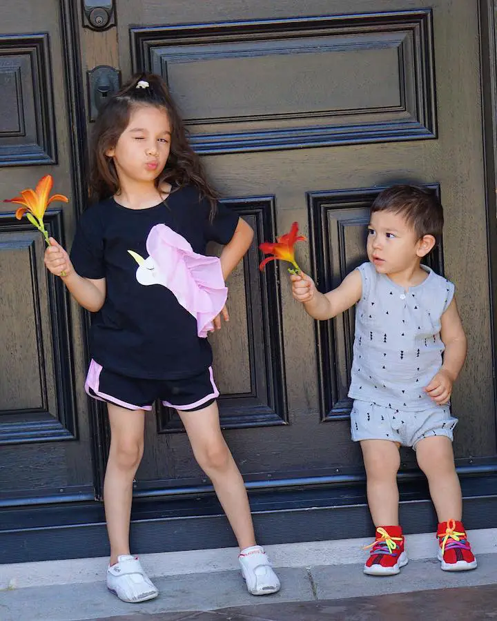 Ranger Ortiz (right) presents his sister Solage Ortiz (left) with a flower who gives a wink at the camera while holding the same species of flower.