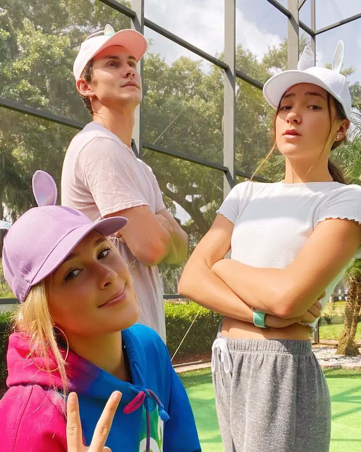 Siblings Allie Schnacky, Colby Schnacky, and Noelle Schnacky, in a green floor backdrop.