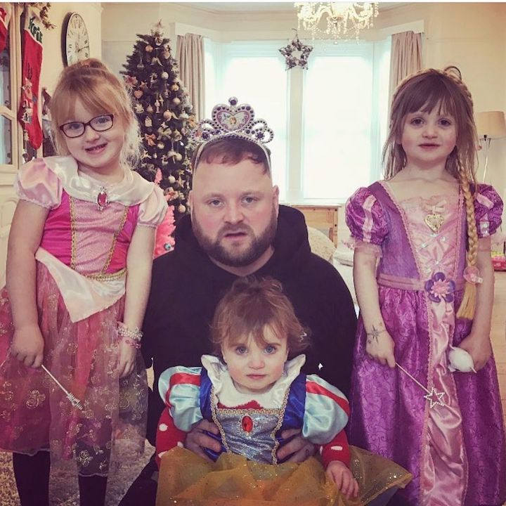 Arron Crascall (center) with his three daughters, one on each of his sides and a toddler being held in front.
